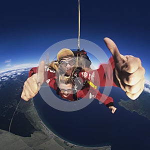 Two skydivers giving thumbs-up in mid-air portrait