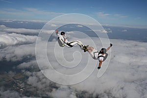 Two skydivers in a sit position while in freefall photo