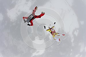 Two skydivers are in the winter sky.