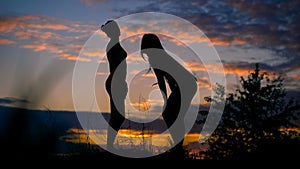 Two slender girl resting after jogging and watching the sunset