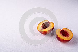 Two slice of peach nectarine fruit with seed on white background, copy space, angle view