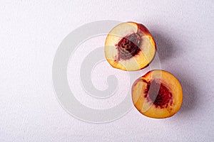 Two slice of peach nectarine fruit with seed on white background, copy space, top view, flat lay