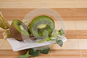 Two sliced kiwis on a white plate