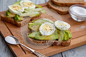 Dos rebanado maduro palta sándwiches huevos pimienta sobre el de madera lámina.. saludable desayuno 