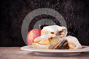 Two slices of apple strudel with spilled powder sugar