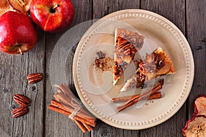Two slices of autumn caramel apple pecan cheesecake, top view table scene over wood