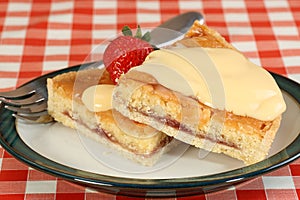 Two slices of bakewell tart with custard