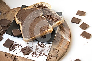 Two slices of bread on wooden plate with chocolate pasta and hail, Dutch hagelslag