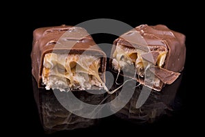 Two slices of Snickers bars on a black macro photo