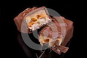 Two slices of Snickers bars on a black macro photo