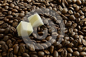Two slices of sugar on a background of coffee beans