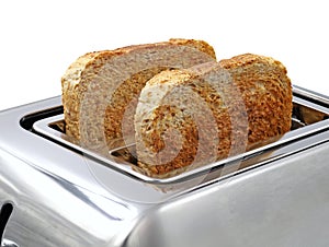 two slices of toasted wholemeal bread in silver toaster isolated on white background