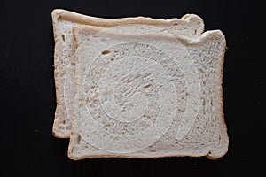 Two slices of white bread on a black background photo