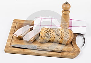 Two slices of whole grain bread with ham and knife