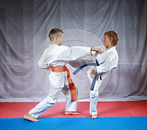 Two small athletes are training paired exercises karate