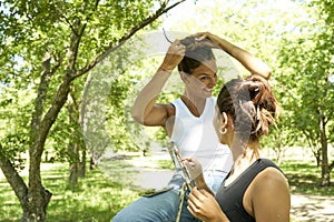 Two small beautiful friends caucasian girls correcting their hair with hands smiling outdoors