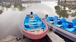 two small boats next to each other at a pier on the water