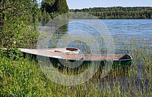 Two small boats standing on the shore of a forest lake