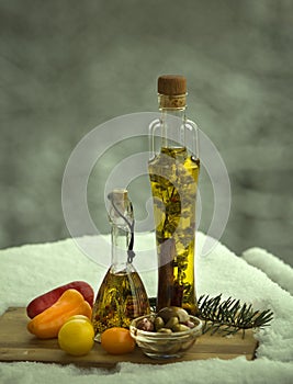 Two small bottles of olive oil and a bowl of olives.
