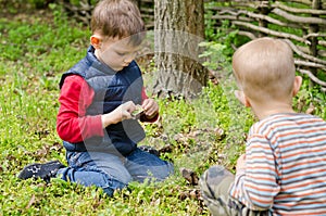 Two small boys lighting a fire in woodland