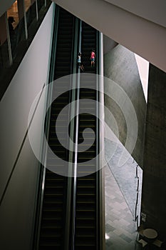 Two small children going up the escalator alone.