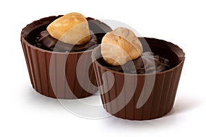 Two small chocolate baskets with cream and nut