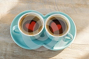 Two small cups of coffee accompanied by heart shaped saucer