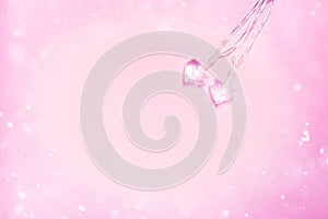 Two small glass hearts on soft pink background. Valentine's day symbol. Decorative element