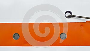 Two small portholes on the white-orange side of the ship close-up