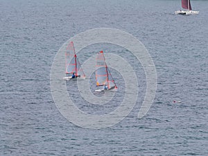 Two small sailboat dinghy cruising in the wind off the coast of Falmouth