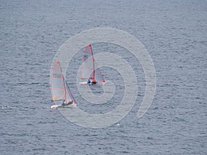 Two small sailboat dinghy cruising in the wind off the coast of Falmouth Cornwall