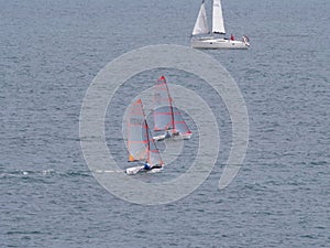 Two small sailboat dinghy cruising in the wind off the coast of Falmouth Cornwall