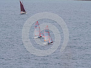 Two small sailboat dinghy cruising in the wind off the coast of Falmouth Cornwall