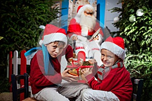 Two small Santa Clauses contending a gift