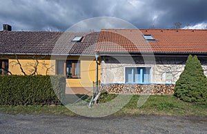 Two small village houses with red roof and blue  window