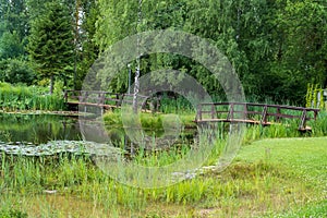 Two small wooden bridges between small ponds in a well-kept beautiful park