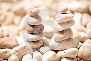 Two small zen towers of five stones on pebble beach