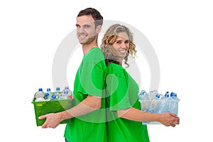 Two smiling activists holding box of recyclables and standing ba