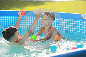two smiling boys are playing in swimming pool. Summer vacation or classes. Summertime and swimming activities for happy
