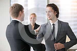 Two smiling businessmen handshaking