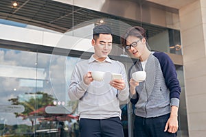 Two smiling businessmen walking and talking in the city