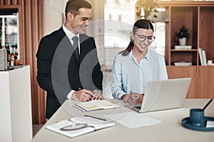 Two smiling businesspeople working together in an modern office