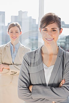 Two smiling businesswomen looking at camera with arms crossed