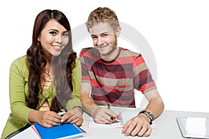 Two smiling college students studying together