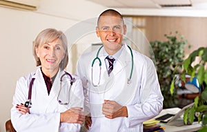 Two smiling confident doctors standing in medical office
