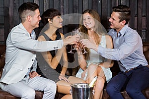 Two smiling couple toasting glasses of champagne