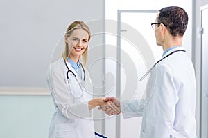 Dos doctores en blanco abrigos sacudida manos 