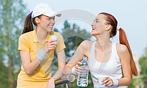 Two smiling girl friends in sports clothing