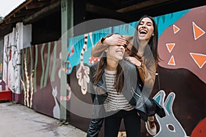 Two smiling girls having fun on the street