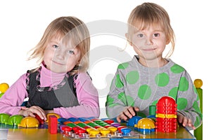 Two smiling girls playing vivid toys